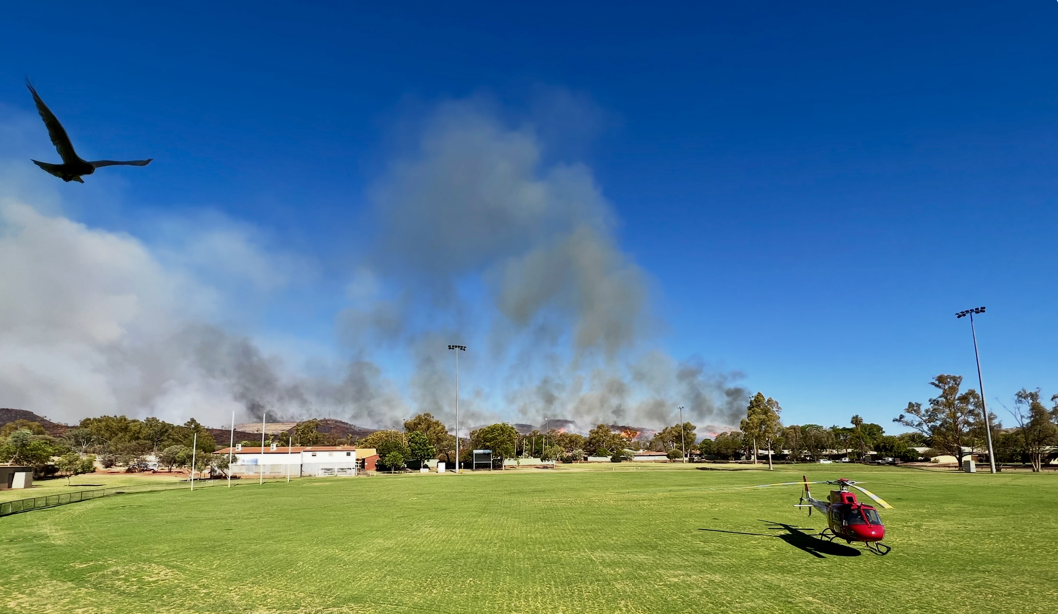 Bushfire incident smoke column with emergency aviation operations in Western Australia