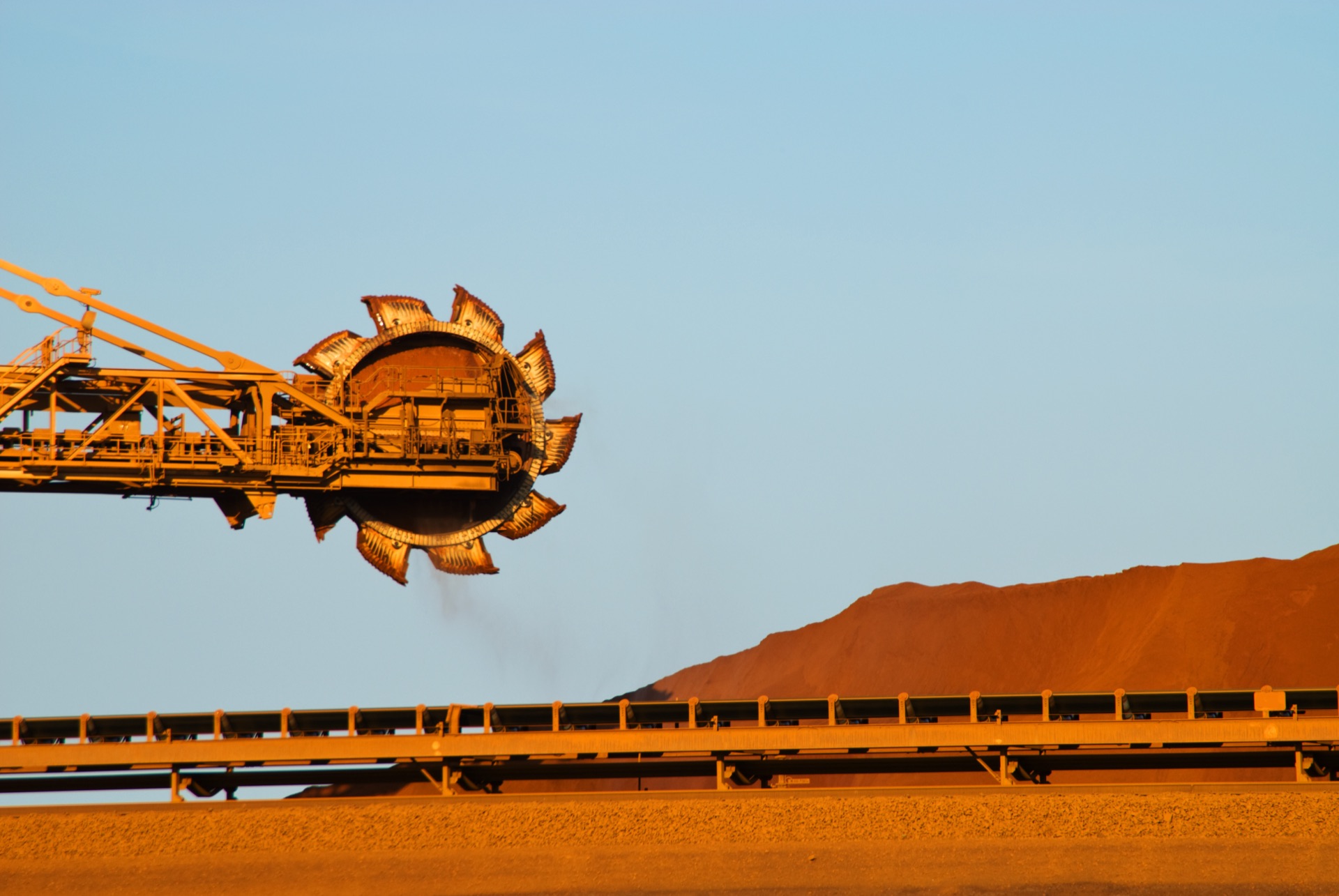 Bucket wheel reclaimer at an iron ore mine site at sunset in Western Australia